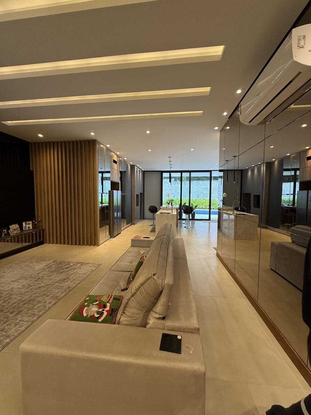 Sala de estar: Sancas de LED em linhas paralelas no forro e spots embutidos ao longo da sala.